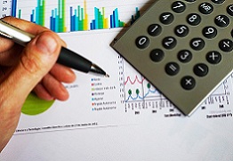 calculadora, caneta e gráficos, simbolizando o planejamento orçamentário e financeiro.